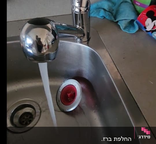 ברז מטבח עם מים זורמים בכיור